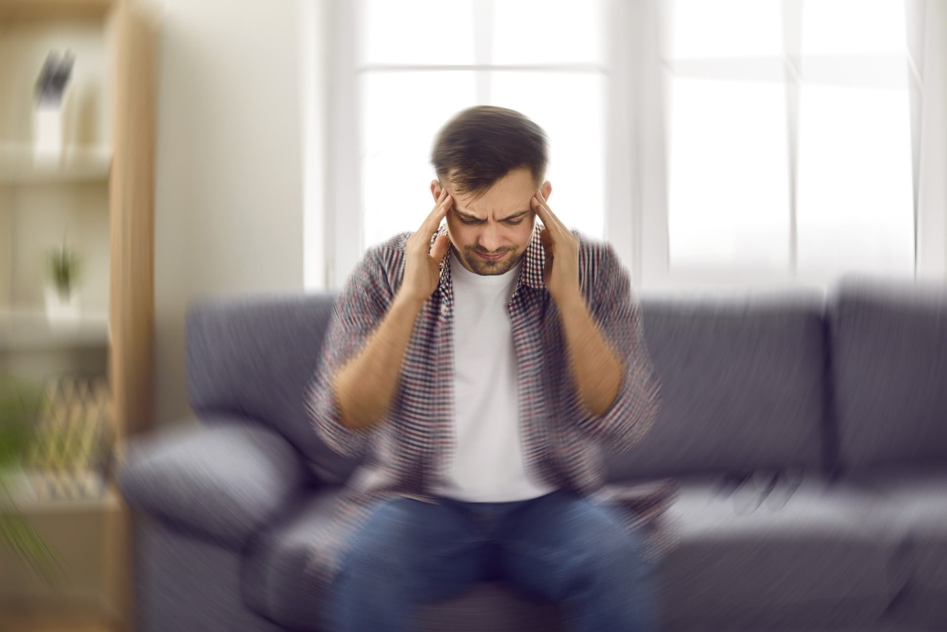 A man holding his head in distress after struggling to get life insurance